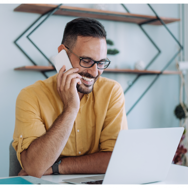 Smiling Man on Phone Call and Computer